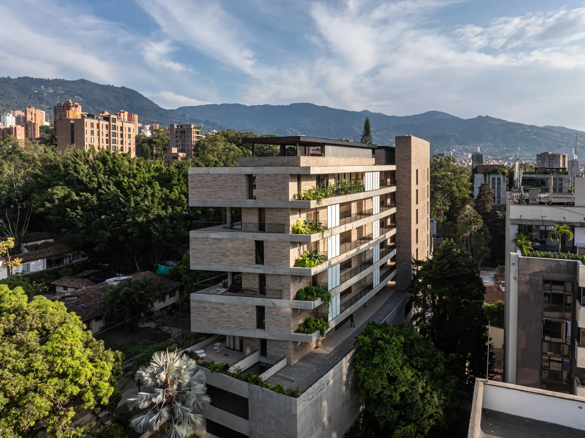 Interior de apartamento con muros de concreto a la vista y ventanales corredizos.